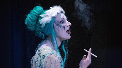 A ballerina with blue hair in a blue dress smoking a cigarette