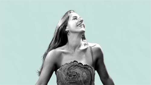 balck and white image of a women looking to the right wearing a dress agagint a blue background
