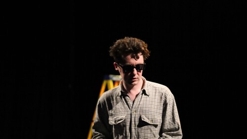 A young dishevelled man with dark shades on