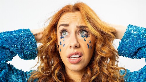 A woman cries tears made of blue glitter
