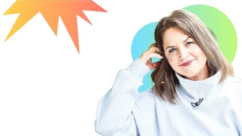 Photo of Ruth Jones wearing a light grey jumper her head is resting on her arm as she smiles at the camera