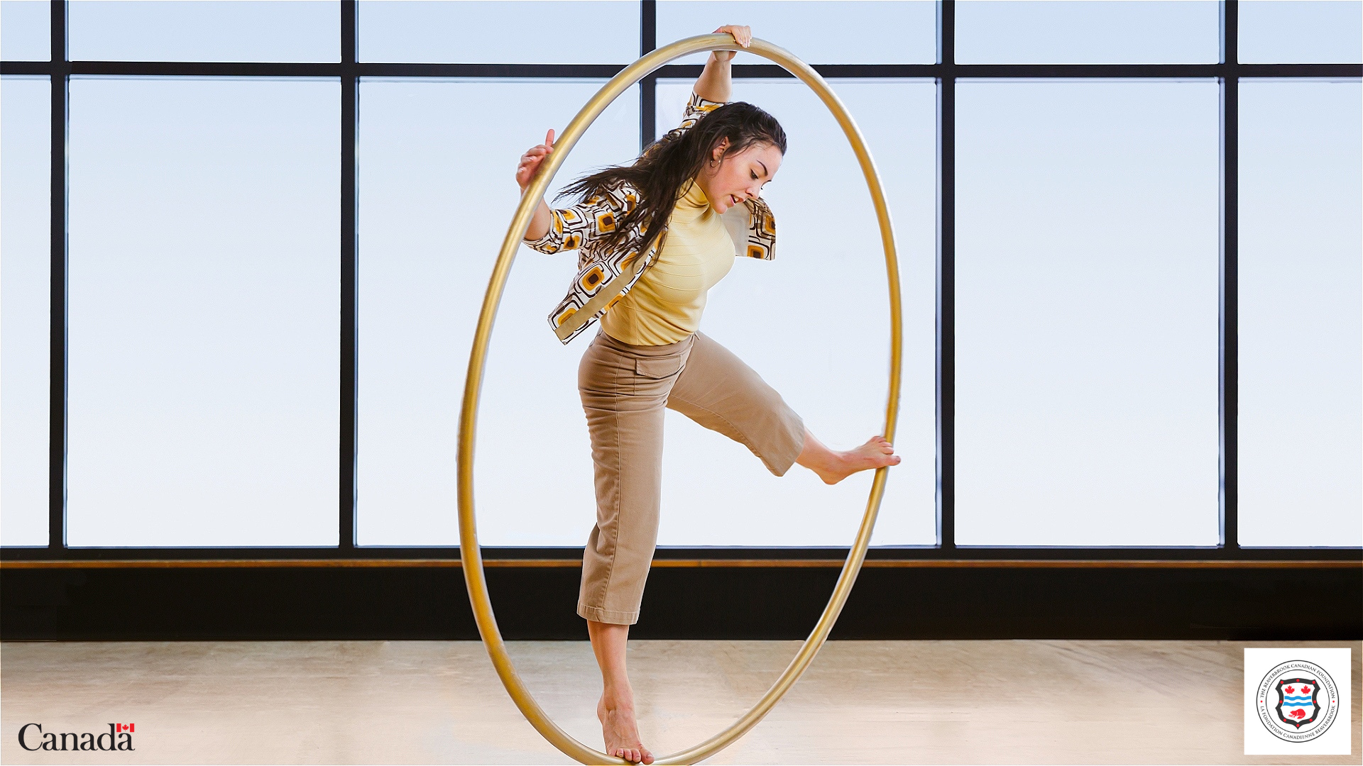 a female acroabatic performer balancing inside a large hoop 