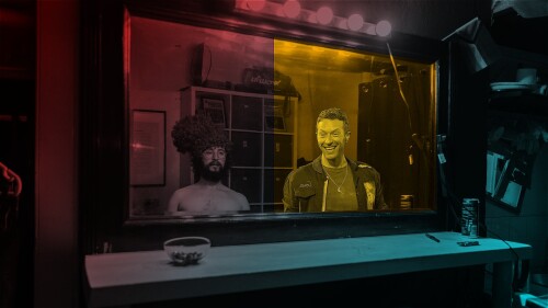 Will and Chris Martin look into a mirror. The world around them is colourful, but the world inside Chris' mirror is only Yellow. Chris Martin Grins.