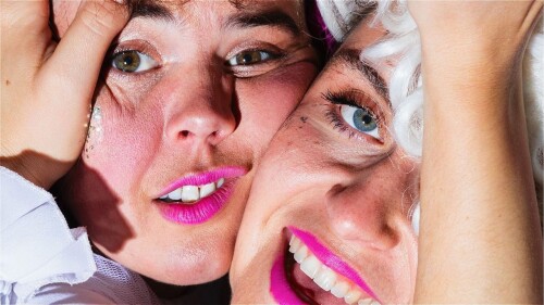 Two female faces squeezed together hugging with glittery make up