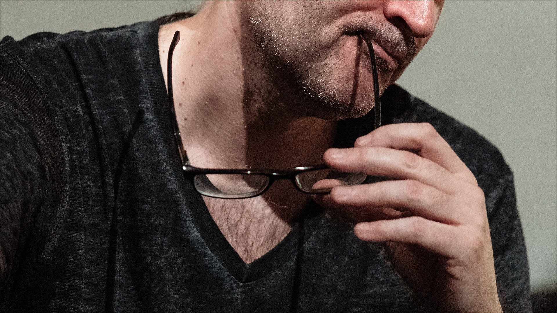 Comedy Reviewer watching a show with his glasses leg lodged firmly in the corner of his mouth