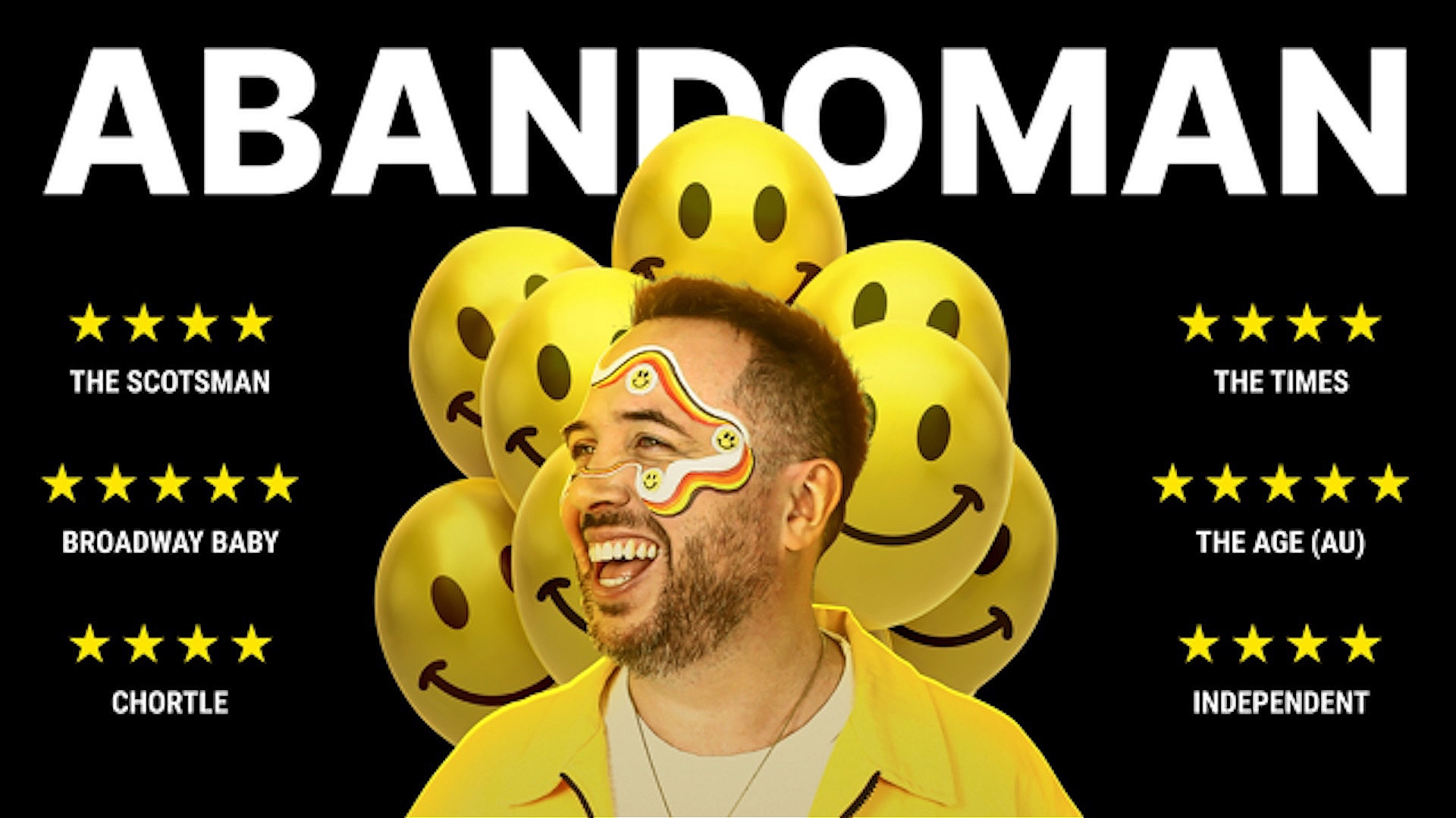 A man with rainbow face paint and a yellow jacket smiles under the word ABANDOMAN in bold white letters