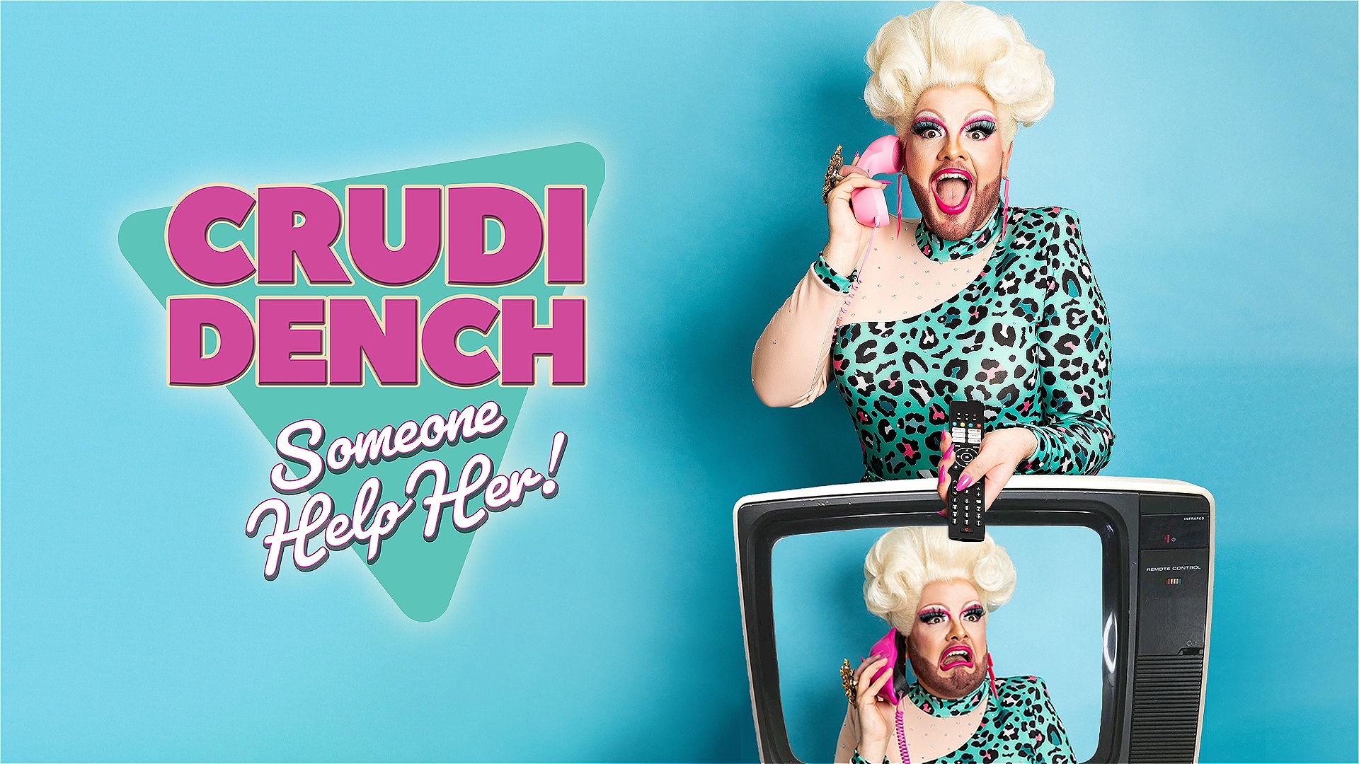 Crudi Dench, a drag queen with a large curly white wig and a brown beard is answering a pink telephone in one hand and holding a tv remote in the other. She is standing behind a white television which displays Crudi with another telephone and a grimace o