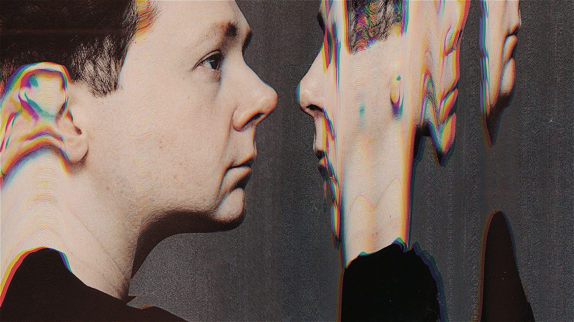 Profile view of a man facing his own digitally distorted reflection, with chromatic aberration and glitch effects warping the mirrored face against a dark background.