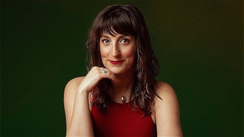 A person sits at a table with 3 red apples in front of them