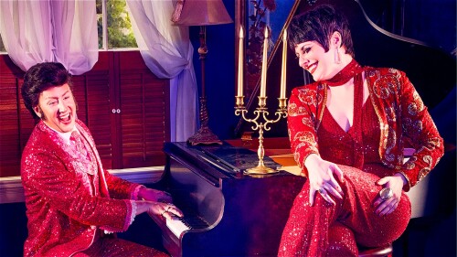 Image shows Liberace playing the piano while Liza looks on.